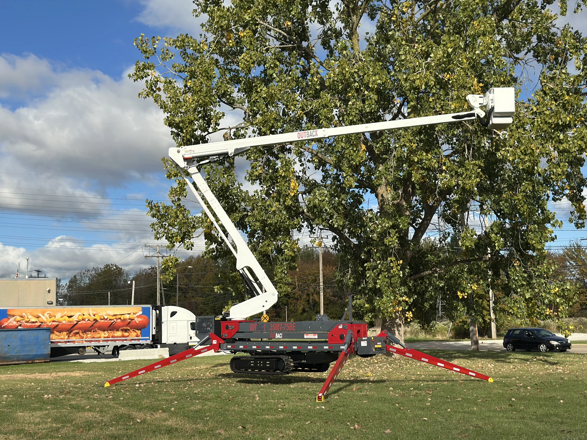 Custom tracked equipment with an articulated boom and deployed outriggers